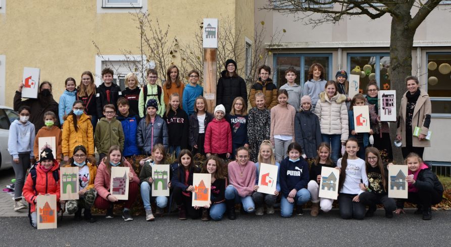 Schülerinnen und Schüler der Kunstklasse 5 des Fraunhofer-Gymnasiums mit ihrer Lehrerin Simone Seifert sowie Julia Breu und Andi Dünne vom KUNSTbeTRIEB Cham präsentieren ihre Werke vor einer der Stelen, die im gesamten Stadtgebiet von Cham aufgestellt wurden. 