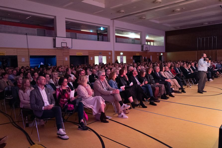 Gebannt lauschen die Gäste in der voll besetzten Sporthalle den lustigen Ausführungen ...