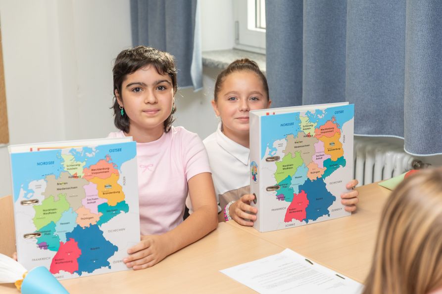 Stolz präsentieren die neuen Fünftklässler ihre Willkommens-Geschenke.