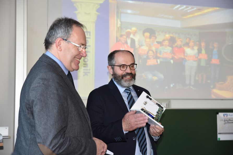 Schulleiter Dr. Hubert Balk bedankt sich bei Max Kulzer vom Landratsamt Cham für die langjährige vertrauensvolle Zusammenarbeit und wünscht ihm für seinen Ruhestand alles Gute. Als kleines Geschenk erhält der gelernte Radio- und Fernsehtechniker ein eigens für ihn gebautes Mittelwellenradio vom Chamer Rundfunkmuseum.