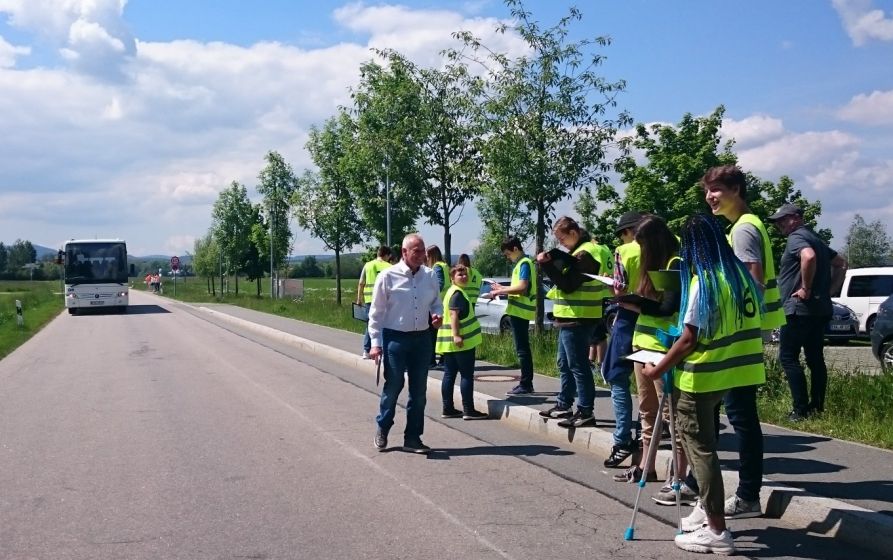 Die Teilnehmer des Bezirkswettbewerbs im Mai 2019 beim Schätzen der Geschwindigkeit eines heranfahrenden Busses.