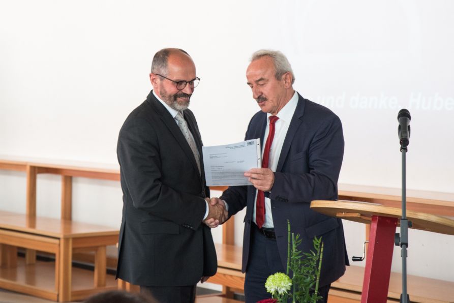 Der Ministerialbeauftragte für die Gymnasien in der Oberpfalz, Ltd. OStD Franz X. Huber, überreicht die Urkunde zum Eintritt in den Ruhestand an den scheidenden Schulleiter Dr. Hubert Balk
