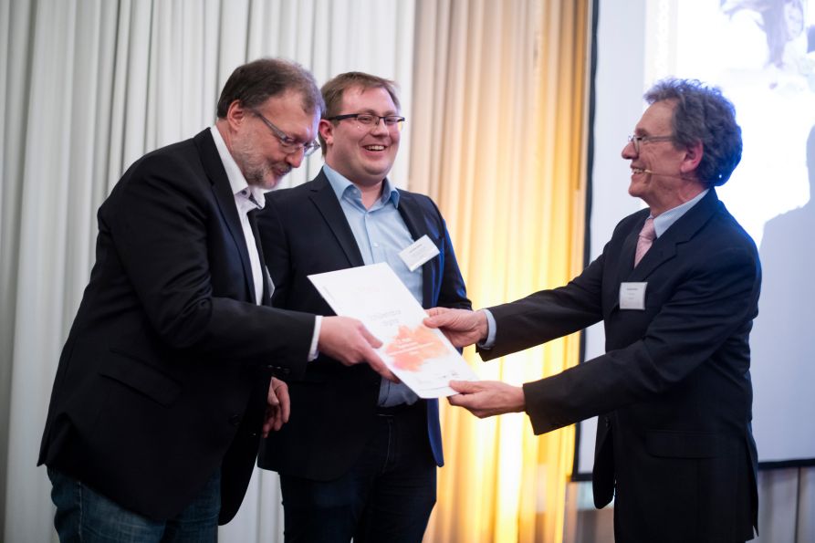 Die Fraunhofer-Lehrer StD Robert Wagenbrenner und StR Joachim Bauer freuen sich über den LernortLabor-Preis, der ihnen von Dr. Andreas Kratzer von der TU München überreicht wird.