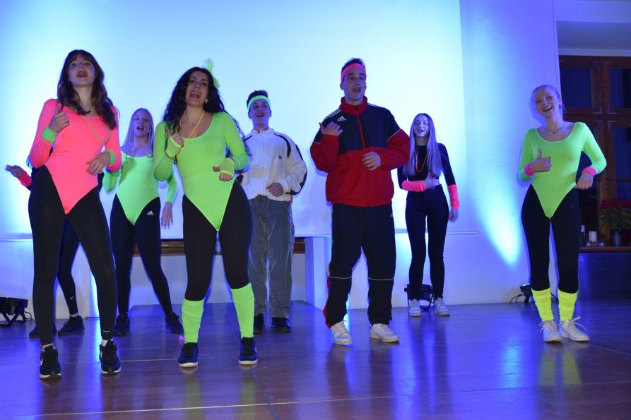 Passend zu „Footloose“: 80er-Jahre Aerobic-Outfit mit Neondress, Stirnband und Stulpen